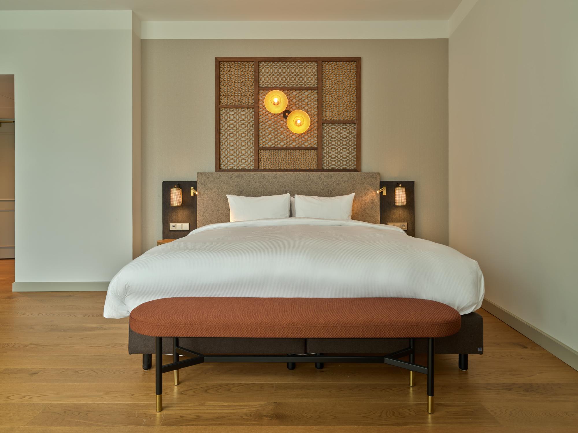 Spacious King Bed with plush headboard and elegant bedding in voco The Hague suite