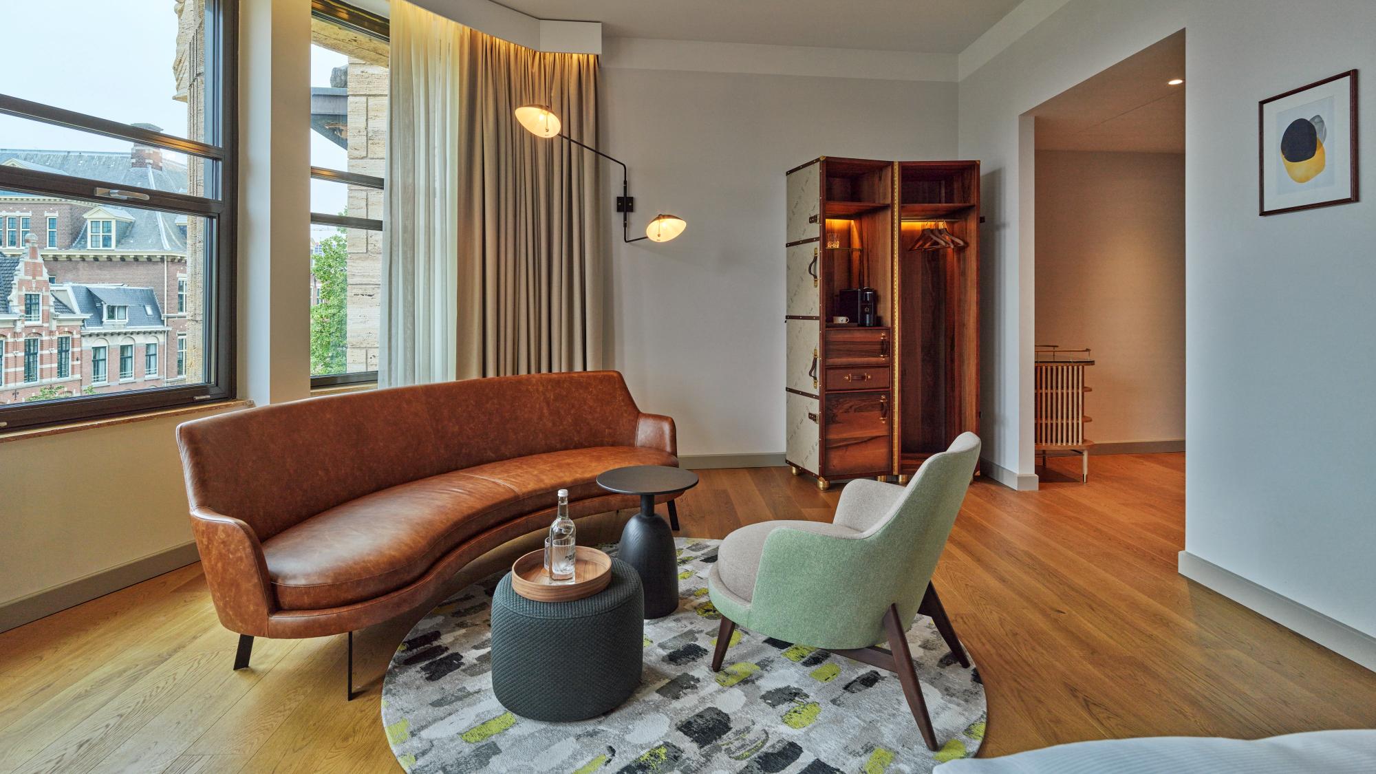 Stylish seating area with sofa bed and coffee table in luxurious King Suite at voco The Hague