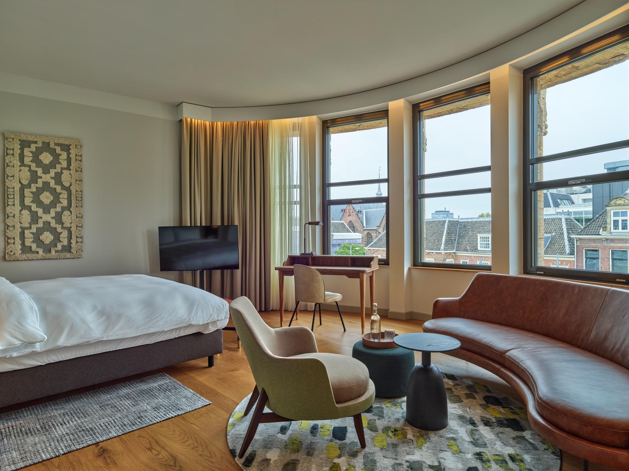King Bed with elegant headboard in the Kneuterdijk Suite at voco The Hague – spacious and stylish bedroom