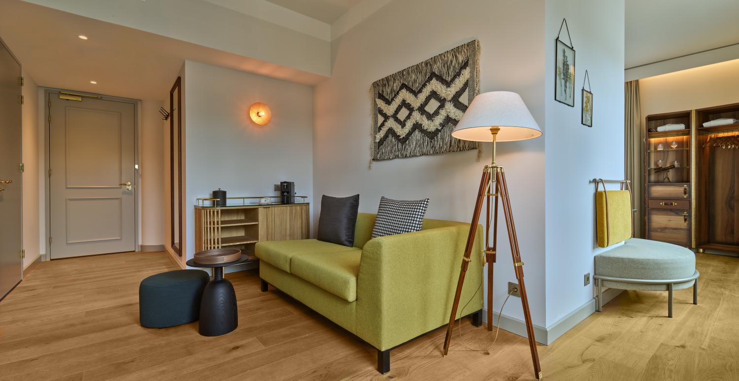 Comfortable lounge space in King Suite with sofa and lamp – voco The Hague