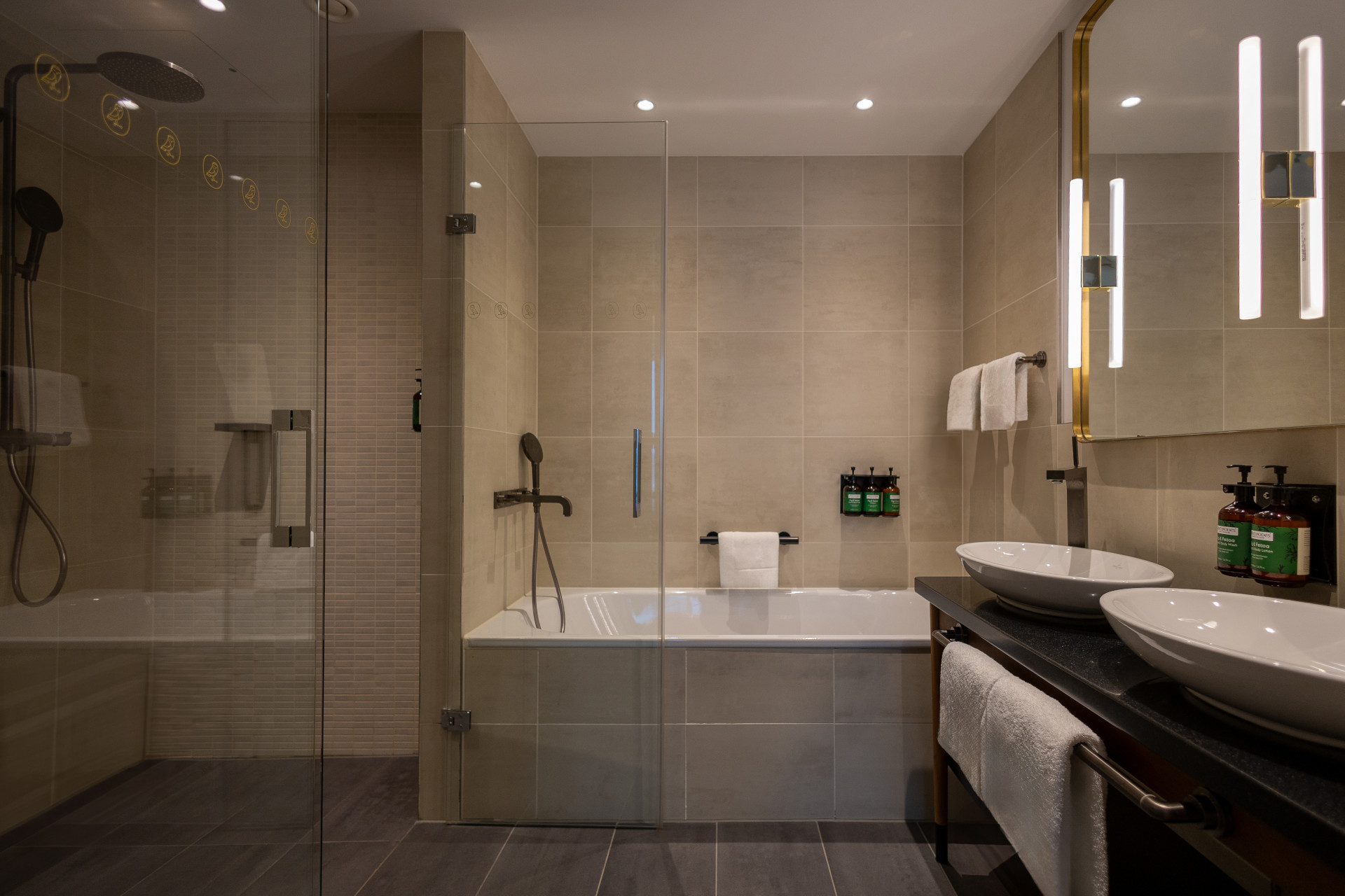 Bathroom vanity with mirror and premium toiletries in King Suite – High Floor at voco The Hague