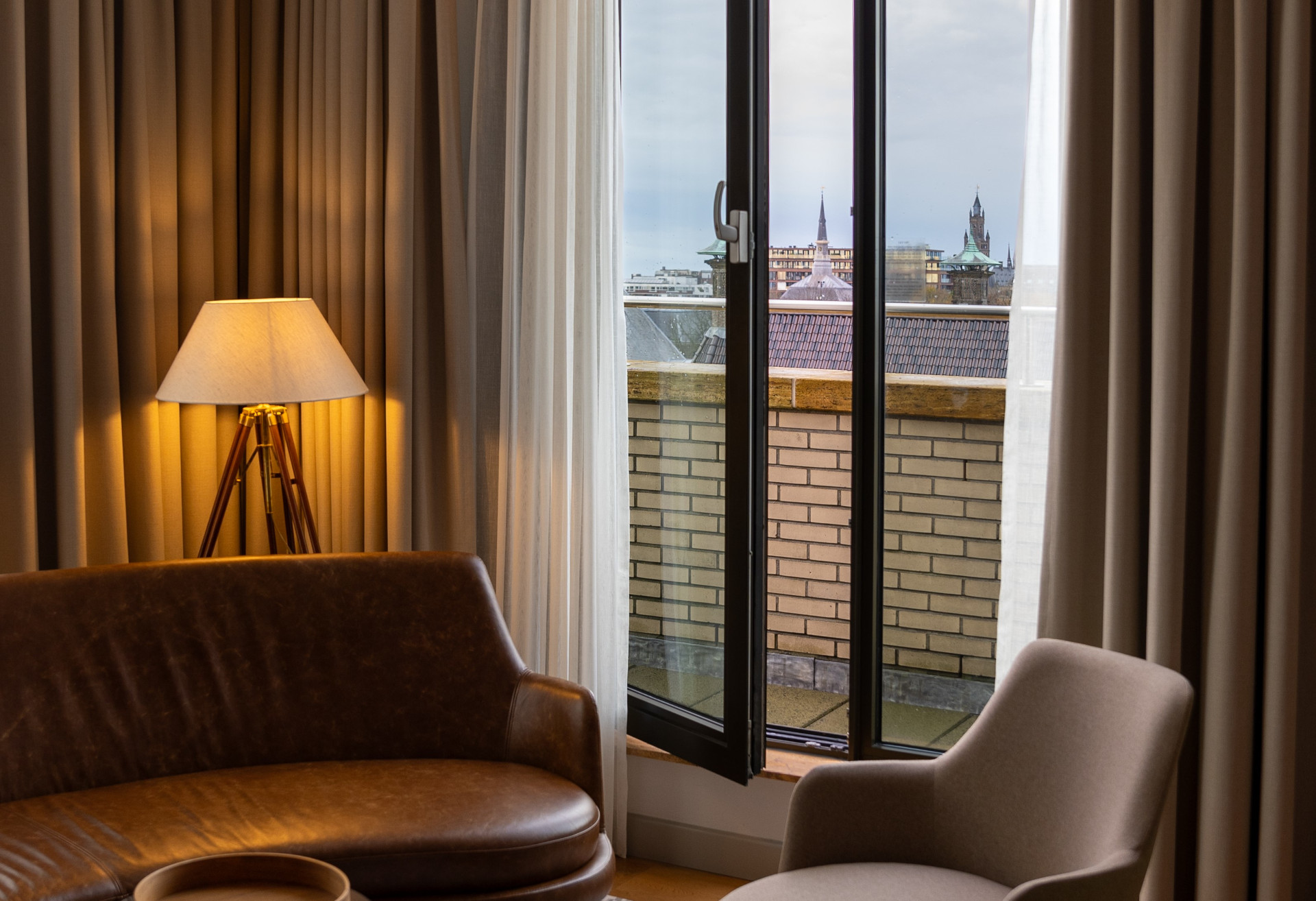 King Suite with balcony and meeting area – voco The Hague, high-floor room with natural light