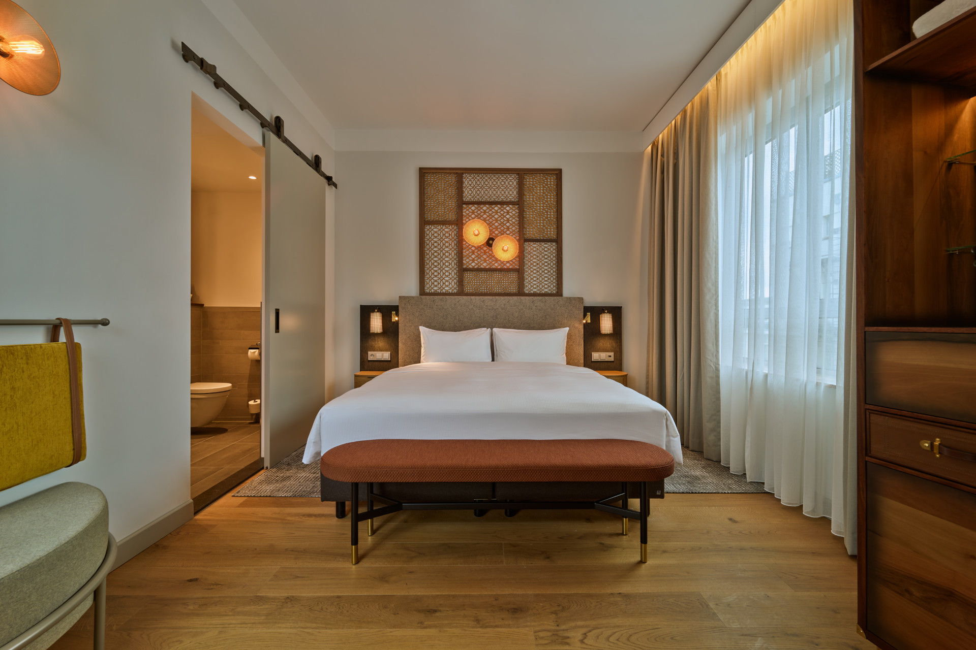 Spacious King Bed with decorative headboard in lounge suite at voco The Hague
