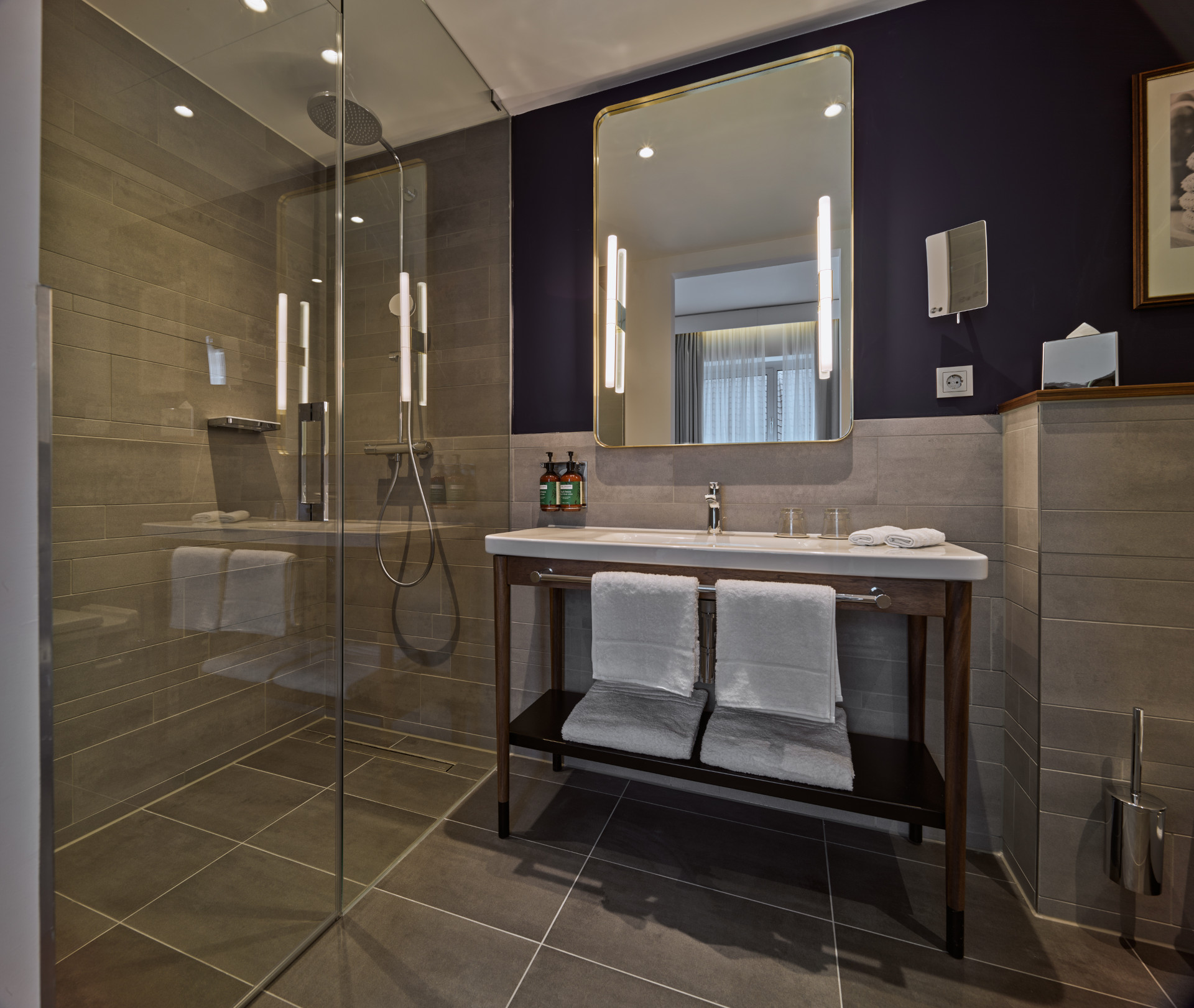 Modern bathroom with blue accents in Premium Atrium Room at voco The Hague