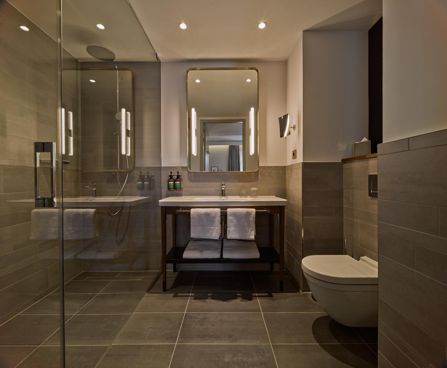Modern bathroom in the Twin Premium Room at voco The Hague – walk-in shower and luxury amenities