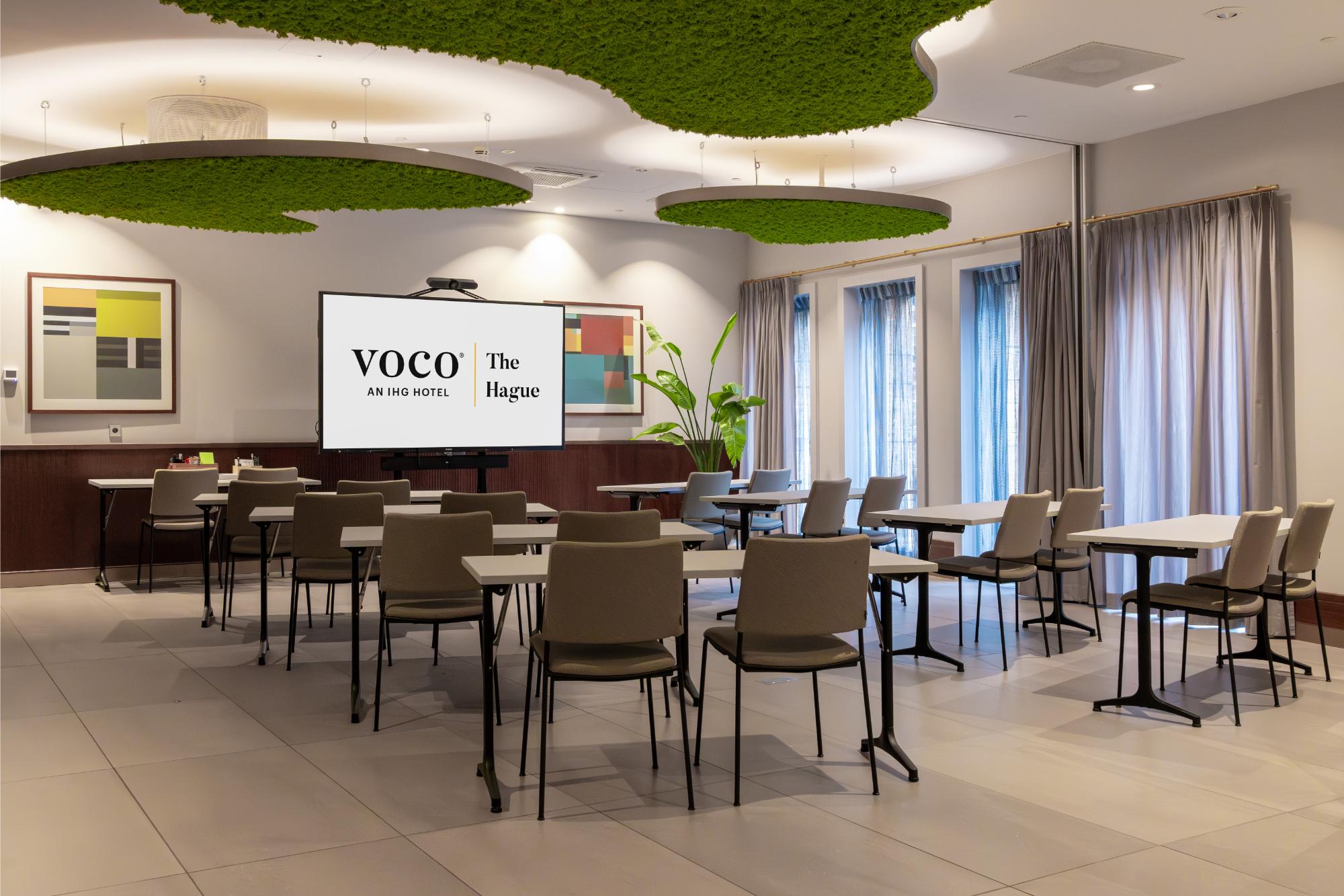 Spacious classroom-style meeting room with greenery ceiling panels – voco The Hague